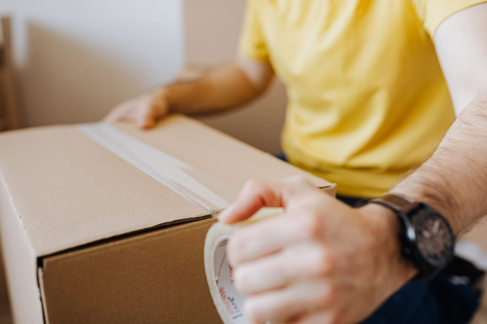 Hands taping up a moving box